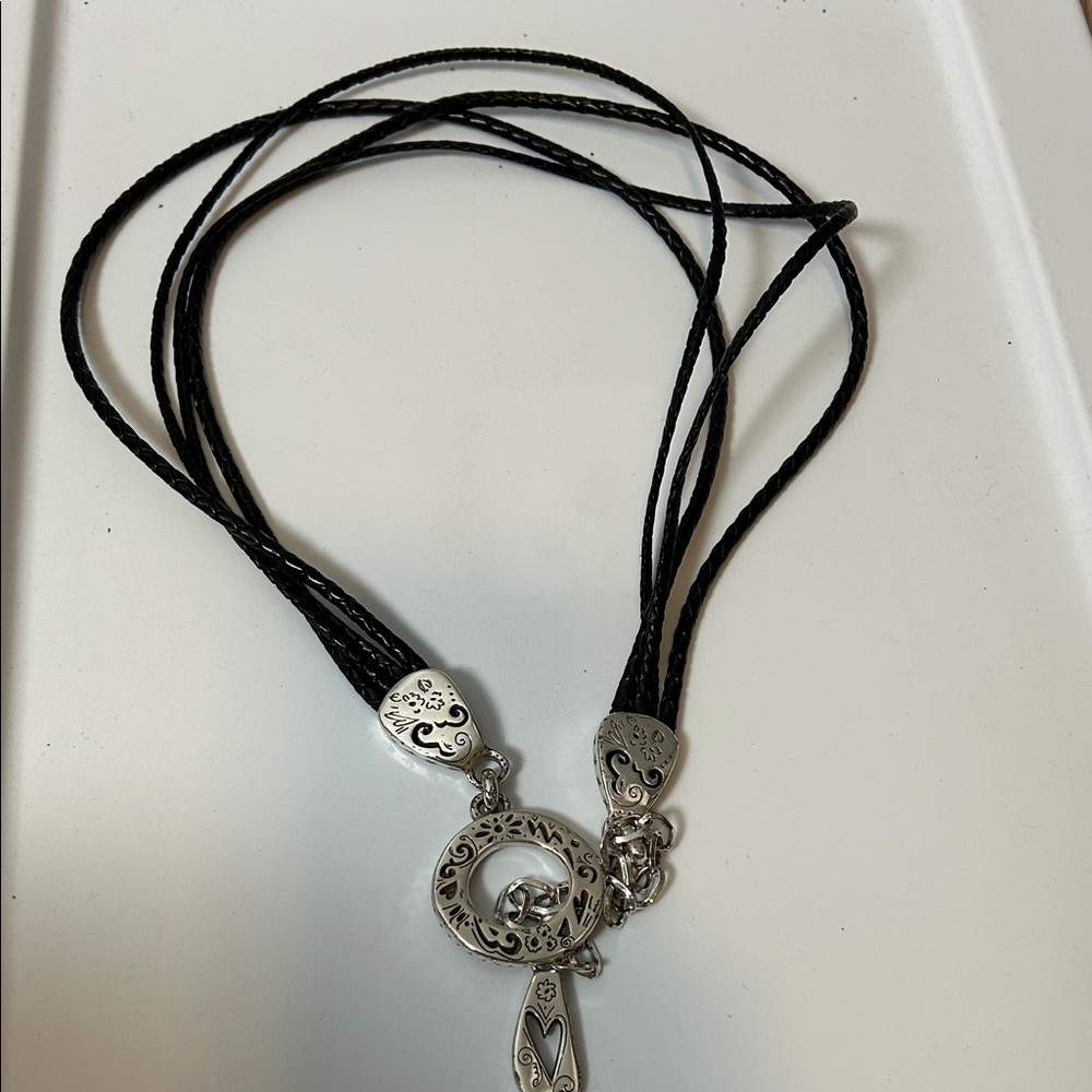 black braided leather belt with ornate silver-tone hardware.